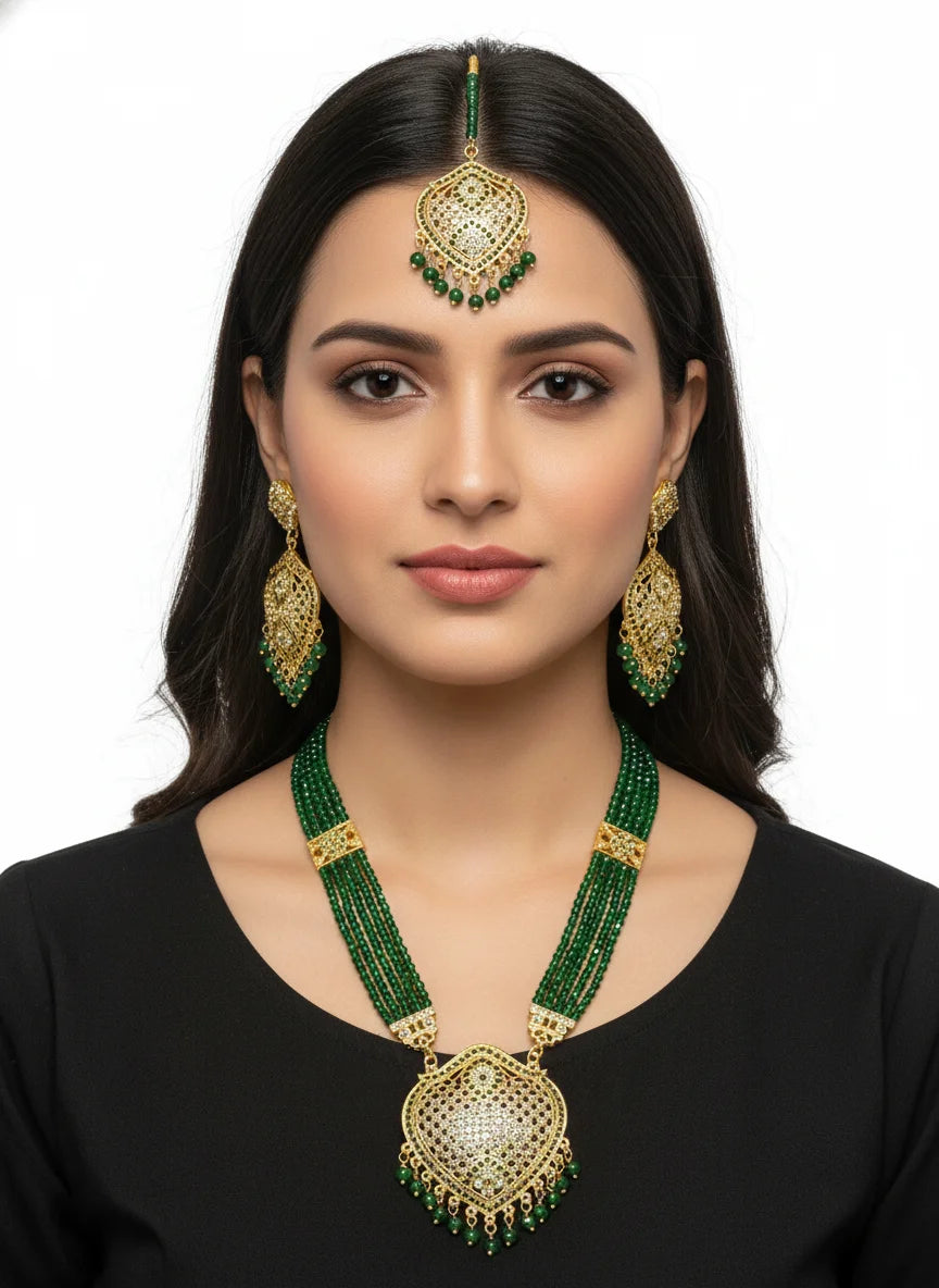 Woman wearing green and gold jewelry set on a white background
