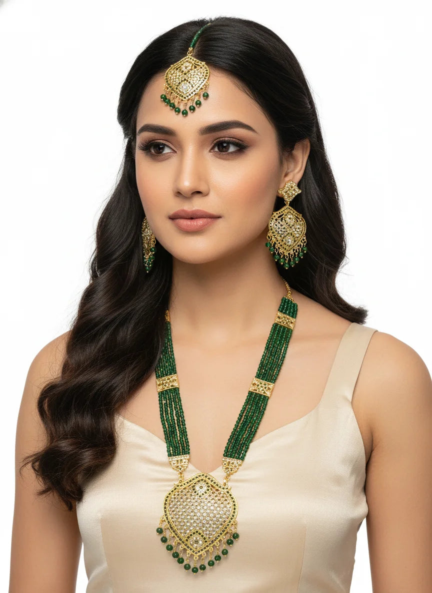 Woman wearing green and gold jewelry set on a white background
