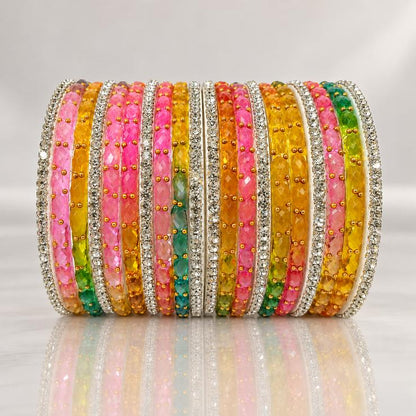 Multicolor crystal bangles stack with stone studded borders on mirror surface
