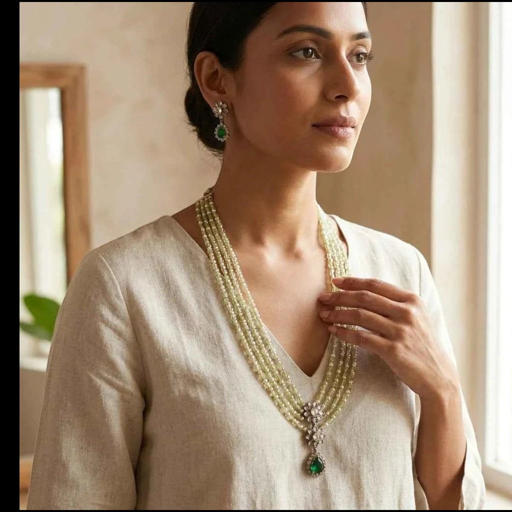 GEHNA OFFICIAL layered green and pearl bead necklace set with American diamond floral pendant and matching earrings.